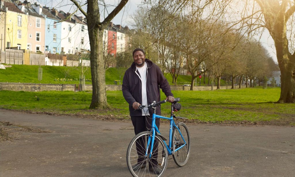Man standing with his bike in Victoria Park Bristol