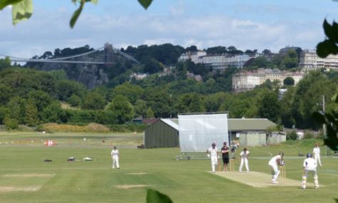Scenic photo of people playing cricket with view of Clifton Suspension Bridge