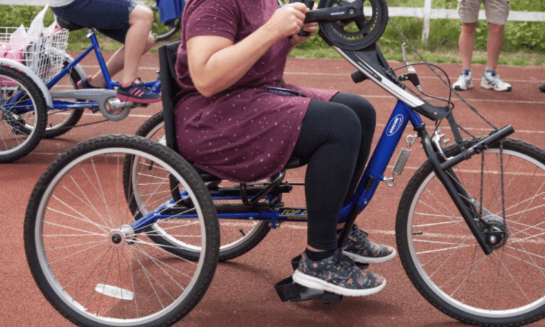 A lady riding a hand cycle